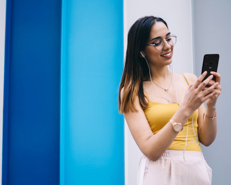 Why Orbic - girl wearing headphones looking at mobile phone